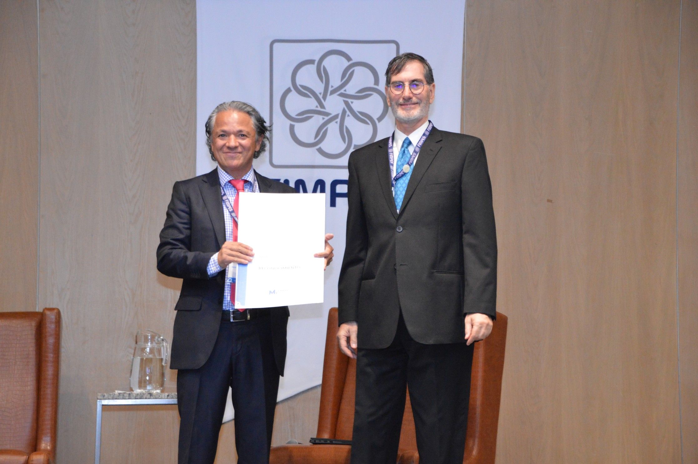 Mario López Roldán, Director del Centro de la OCDE en México para América Latina, recibe el reconocimiento por su participación de manos del Secretario General de la FIMPES, Dr. Bernardo González-Aréchiga
